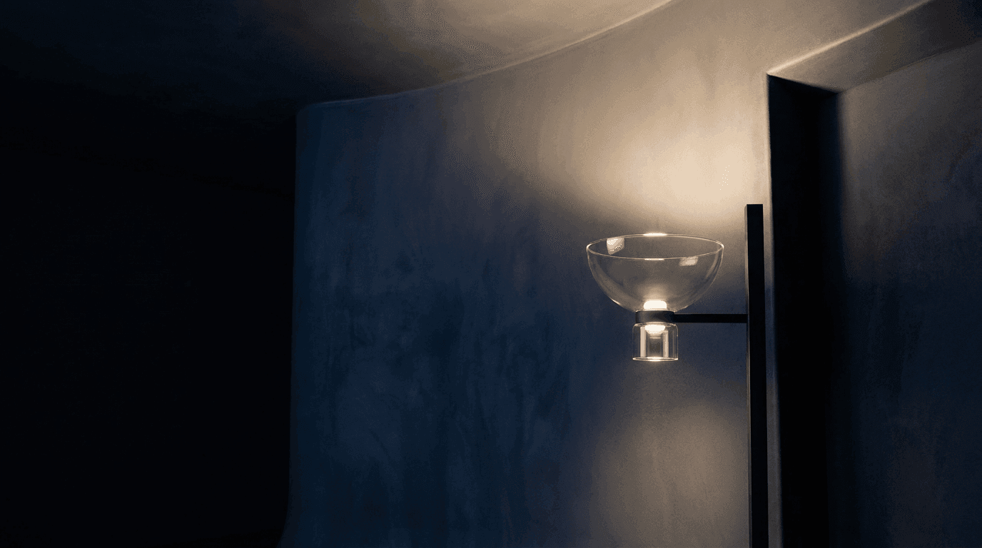 Flos — the sconce beside a doorway in a dark curved room